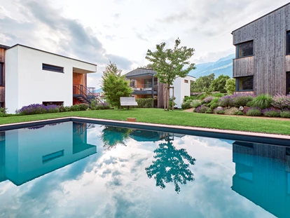 Hüttendorf - Pfunds - Naturpool mit Blick auf die Lodges - Cirna Gentle Luxury Lodges