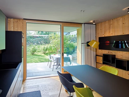 Hüttendorf - Pfunds - Küche und Essbereich mit Blick in den Garten - Cirna Gentle Luxury Lodges