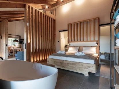 Hüttendorf - Chaletgröße: 8 - 10 Personen - Ganz neu bei uns: Die FORSTGUT.LODGE. Direkt am Gutsplatz gelegen. Schlicht und elegant bietet unser neues Highlight Raum für fünf moderne und luxuriöse Junior-Chalets. Für jeweils zwei Personen.
Mit Wohn- und Schlafbereich in außergewöhnlichem Interior-Design, bodentiefen Fenstern in allen Räumen mit Blick in die unendliche Weite des Bayerischen Waldes, modernster Kücheneinrichtung, großzügigem Duschbad, freistehender Badewanne und eigener Sauna. Unvergleichlich. Zum Ausspannen und Kraft tanken. Unglaublich beruhigend. Im Spiegel der Natur. Weit weg vom Alltag. Mit Inventar für alle Bedürfnisse. Und exquisitem Service: Denn ein reich befüllter Frühstückskorb mit frischen Semmeln wird täglich direkt an die Suite geliefert. - FORSTGUT