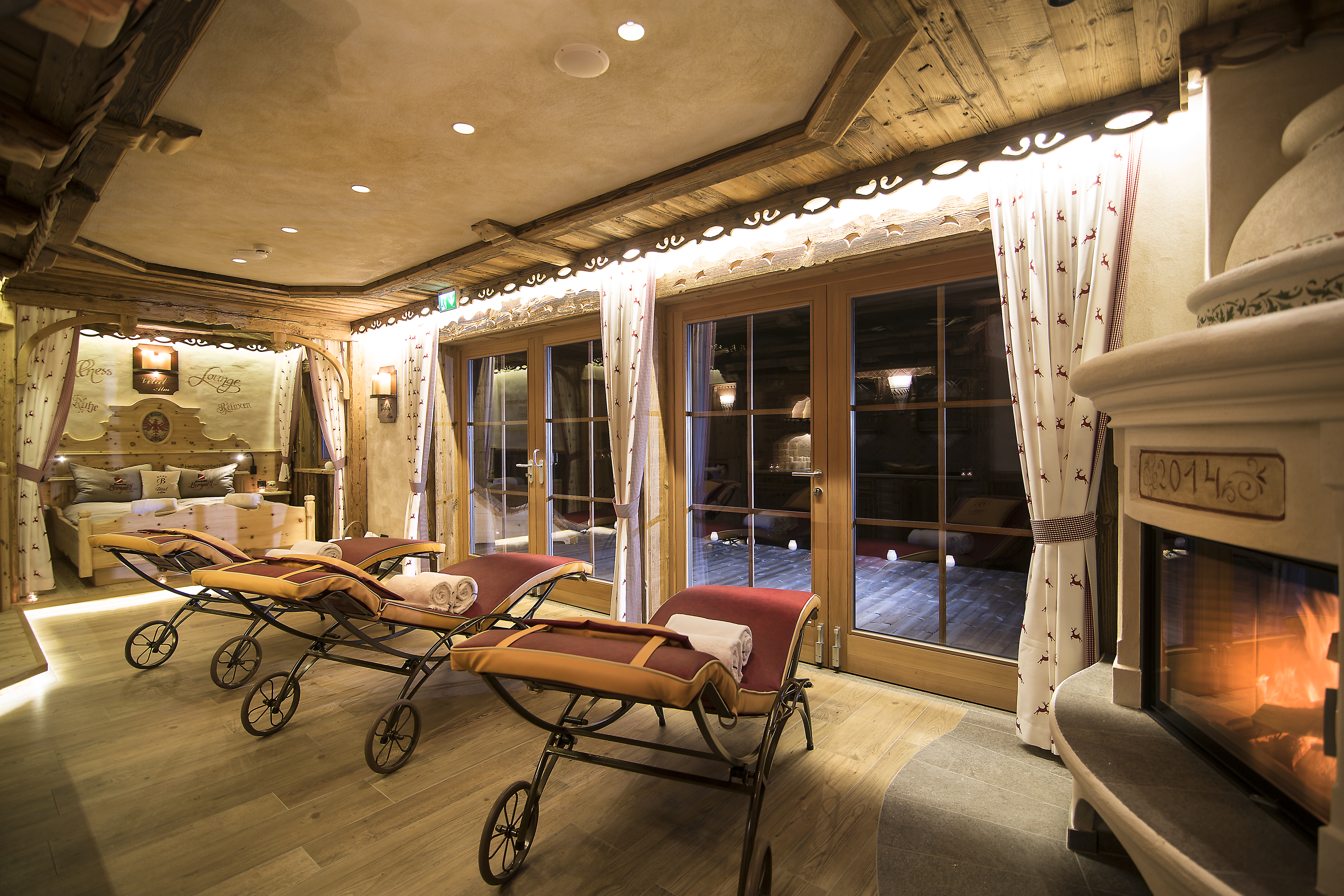 Chalet: Relaxliegen mit Kamin im Ruheraum - Luxus Chalet Bischofer-Bergwelt