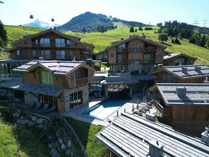 Hüttendorf - Chaletgröße: 4 - 6 Personen - Pinzgau - Sommeransicht des Zaglguts mit Blick auf die umliegenden Chalets und die Gondel im Hintergrund. - Bergdorf Hotel Zaglgut Ski In & Ski Out