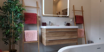 Hüttendorf - Toblach - Badezimmer samt halb freistehender Badewanne, Regenwalddusche & Toilette (erster Stock) - Lodge Mira  - TYROL PURElife Lodges