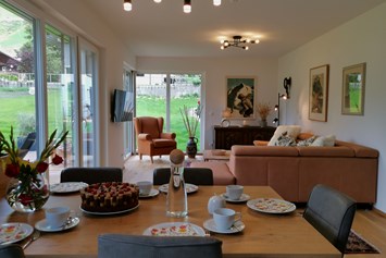 Chalet: Essensbereich & Wohnzimmer mit Blick auf Garten und Bergwelt - Lodge Sirius  - TYROL PURElife Lodges 