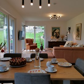 Chalet: Essensbereich & Wohnzimmer mit Blick auf Garten und Bergwelt - Lodge Sirius  - TYROL PURElife Lodges 