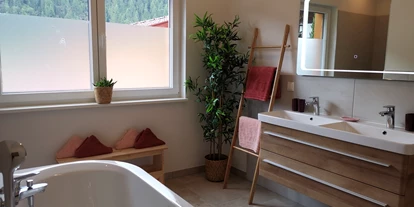 Hüttendorf - Toblach - Badezimmer mit halb freistehender Badewanne, Regenwalddusche & WC (erster Stock) - Lodge Sirius  - TYROL PURElife Lodges