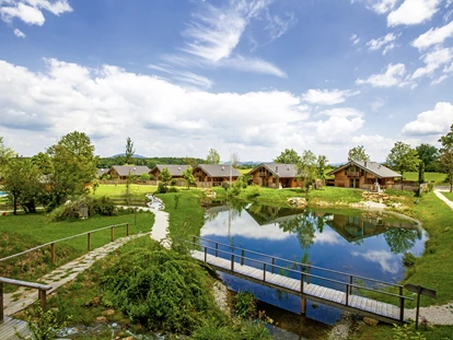 Hüttendorf - Hot Tub: beim Chalet - Das Chaletdorf präsentiert sich bei weiß-blauem Himmel - Bayern Chalets
