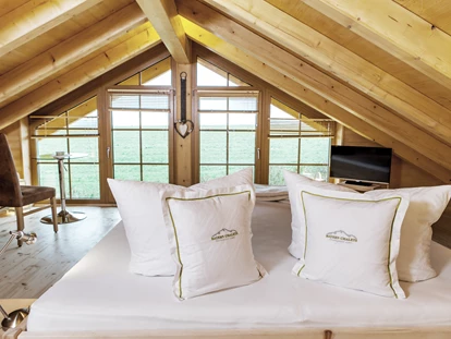Hüttendorf - Hot Tub: beim Chalet - Einige Chalets verfügen neben dem Zirbenholz-Schlafzimmer über eine zusätzliche Entspannungsmöglichkeit im beheizten Wasserbett.  - Bayern Chalets