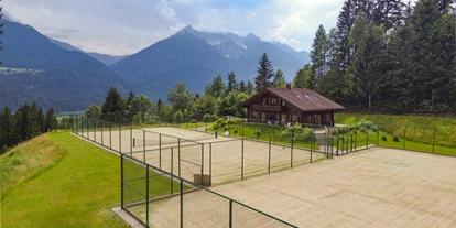 Hüttendorf - Chaletgröße: 8 - 10 Personen - Außenansicht mit Tennisplatz - Glocknerhaus Naturdomizil