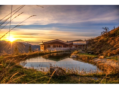 Hüttendorf - Whirlpool: beim Chalet - Sonnenaufgang am Badeteich - STERN MOUNTAIN CHALETS ****