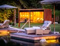 Chalet: Sauna-Kubus in der Parkanlage mit Blick auf den Naturschwimmteich. - Golden Hill Country Chalets & Suites