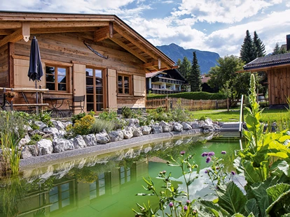 Hüttendorf - Schröcken - Chalet mit Badeteich im Vordergrund - Alpglück Chalets *****