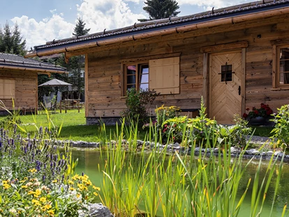 Hüttendorf - Schröcken - Chalets mit Badeteich und Pflanzen im Vordergrund - Alpglück Chalets *****