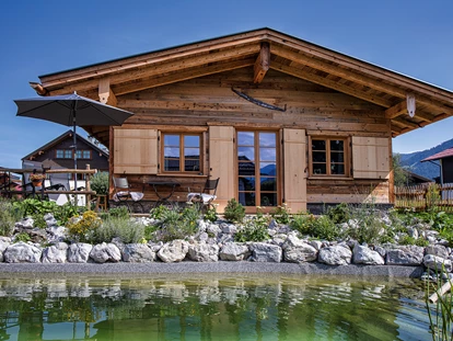 Hüttendorf - Schröcken - Außenansicht vom Chalet Holzar mit Schwimmteich im Vordergrund - Alpglück Chalets *****