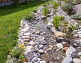 Chalet: Gartenanlage mit alpinem Bachlauf ... freut auf den Besuch von Schmetterlingen, Libellen  - Alpglück Chalets *****