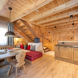Chalet: Wohn / Essbereich mit Elektroofen und Küchenzeile.
Treppe nach oben zu den Schlafzimmern. - Chalets @ Filzmooserhof