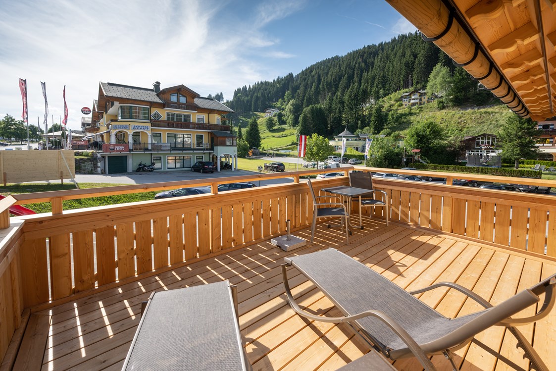 Chalet: Eigener Balkon mit Liegen und Sonnenschirm - Dorf-Chalets Filzmoos