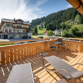 Chalet: Eigener Balkon mit Liegen und Sonnenschirm - Dorf-Chalets Filzmoos