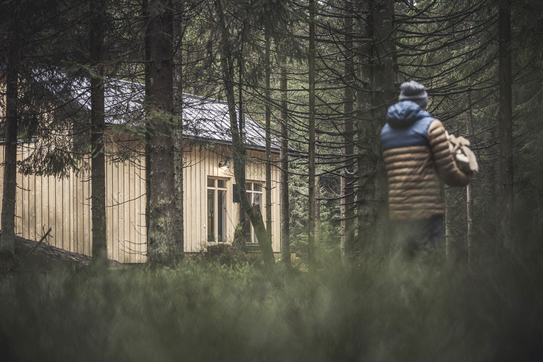 Chalet: Ramenai Böhmerwaldlerdorf | Mann geht mit Kaminholz zur Hütte  - Ramenai - Das Böhmerwaldlerdorf - Außen