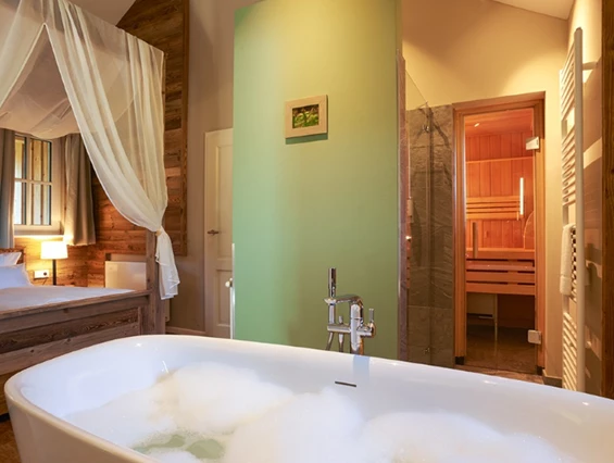 Chalet: Alle Kuschellodges verfügen über eine freistehende Badewanne und Himmelbett.  - Torfhaus HARZRESORT