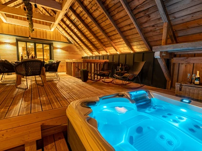 Hüttendorf - Whirlpool: beim Chalet - Scheunenloft - bis 4 Personen 
Dachloggia am Abend  
beheizter Whirlpool - Das MUSSEA Landhaus Chalet & Scheunenloft