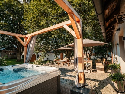 Hüttendorf - Whirlpool: beim Chalet - Landhaus Chalet für 2 Personen 
Terrasse mit Whirlpool - Das MUSSEA Landhaus Chalet & Scheunenloft