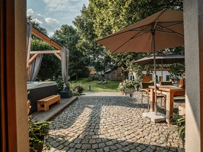 Hüttendorf - Whirlpool: beim Chalet - Landhaus Chalet für 2 Personen 
"Haustürblick" heraus auf die Terrasse - Das MUSSEA Landhaus Chalet & Scheunenloft