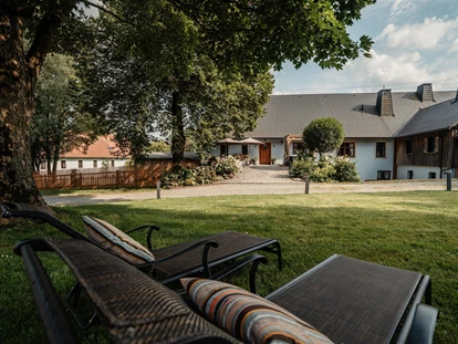 Hüttendorf - Whirlpool: beim Chalet - Landhaus Chalet für 2 Personen 
Blick aus dem Garten auf die private Terrasse - Das MUSSEA Landhaus Chalet & Scheunenloft