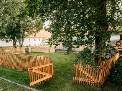 Hüttendorf - Whirlpool: beim Chalet - Landhaus Chalet für 2 Personen 
1,40 Meter hoch eingezäunte Flitzewiese für die Hunde - Das MUSSEA Landhaus Chalet & Scheunenloft