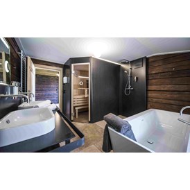 Chalet: Auch in 400 Jahre alten Gemäuern braucht man in diesem Chalet auf modernen Komfort nicht verzichten. Badezimmer mit Badewanne, Dusche und Sauna. - Alpenchalet KÄTH & NANEI
