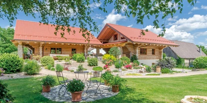Hüttendorf - Parkplatz direkt an der Hütte - Außenansicht der Chalets Morgensonne und Abendrot mit Garten - Heumanns Blockhäuser am Wald