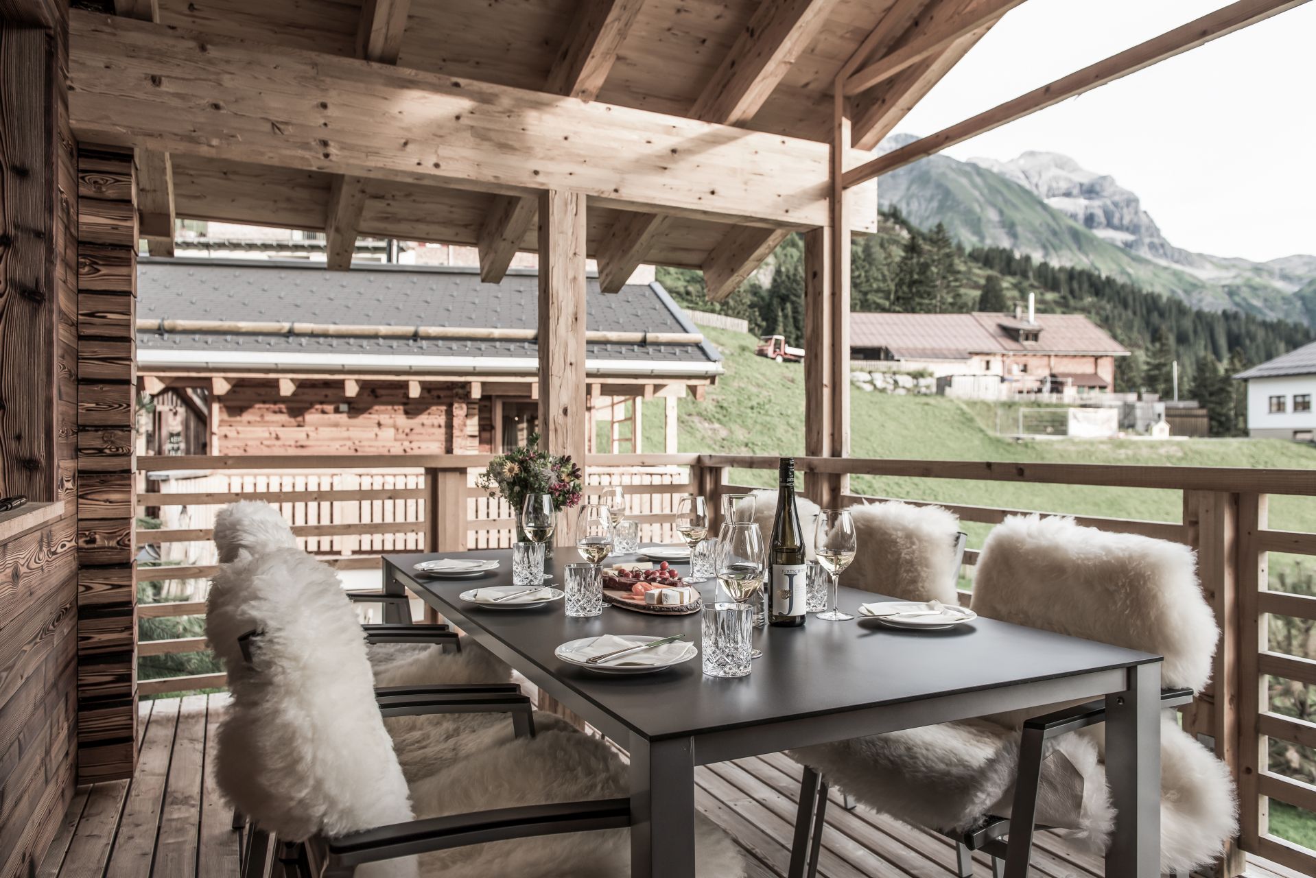 Chalet: überdachter Außemsitzplatz mit Möbeln, Fellen, Laternen... - Aadla Walser-Chalets am Arlberg - Außen