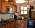 Chalet: hochwertige Küche samt Kochplatte und Holzherd - Enzianhütte