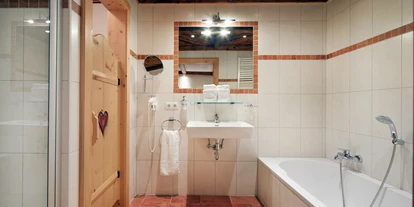 Hüttendorf - Snow Space Salzburg - Flachau - Wagrain - St. Johann - Badezimmer en suite mit Badewanne/Dusche/WC/Fön/Kosmetikspiegel - Almdorf Flachau