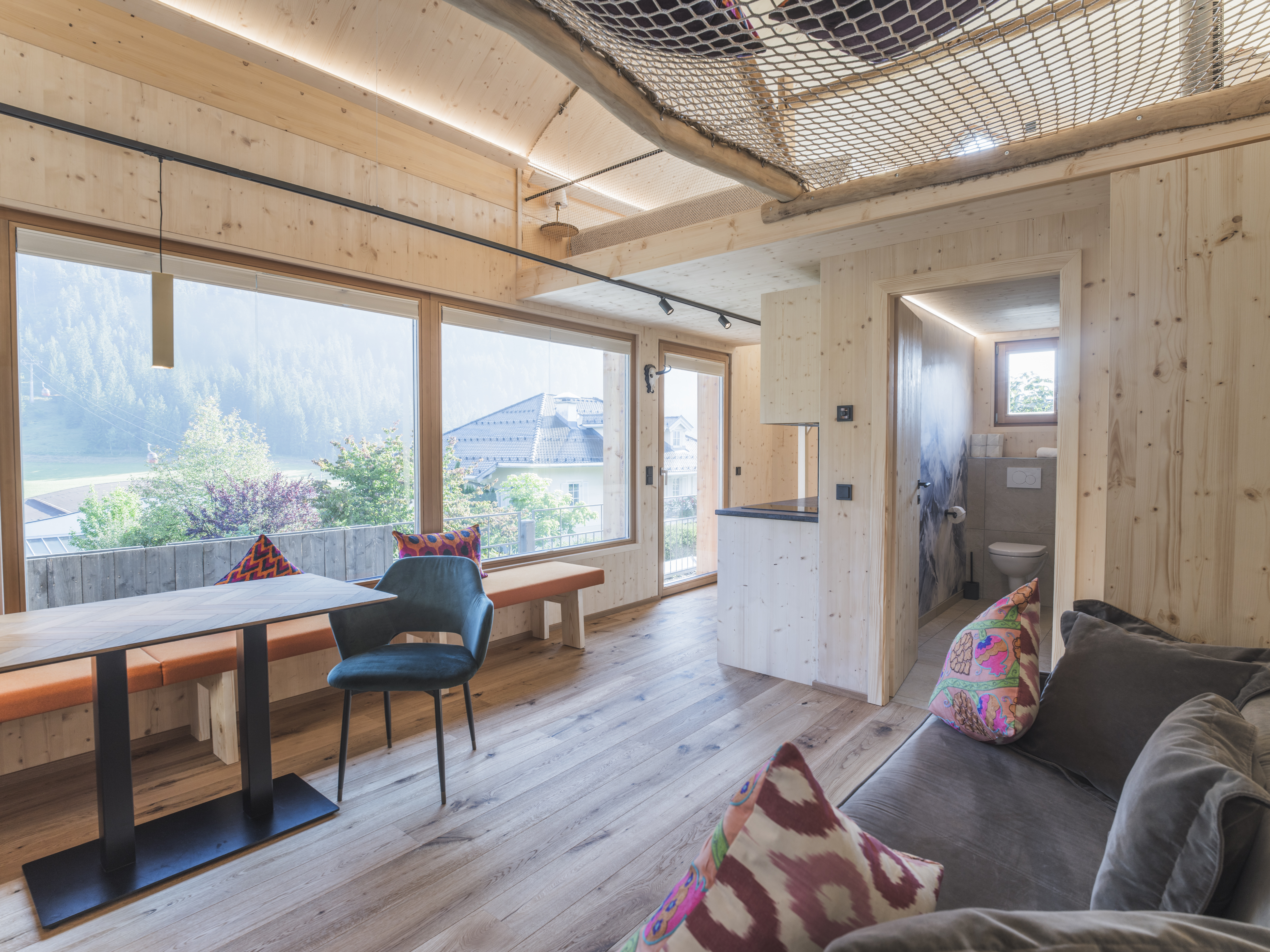 Chalet: Gemütlicher Wohn- und Essbereich mit Küche mit Blick auf die Steinplatte -  im Tiny Chalet Kalipé - ALPEGG CHALETS