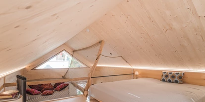Hüttendorf - Weng (Goldegg) - Kuscheliger Schlafbereich im Tiny Chalet Kalipé mit Doppelbett und gemütlicher Hängeseilbrücke zum Entspannen. - ALPEGG CHALETS