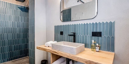 Hüttendorf - Weng (Goldegg) - Im Casa Defrancesco - Badezimmer mit Dusche, Waschbecken, frischen Handtüchern und Pflegeartikeln. - ALPEGG CHALETS