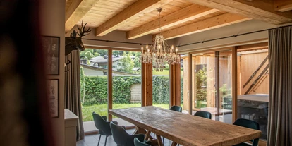 Hüttendorf - Weng (Goldegg) - Main Lodge: Großes Esszimmer mit Panoramafenstern und Blick auf den Garten, wo private Sauna und Whirlpool für entspannte Stunden warten. - ALPEGG CHALETS