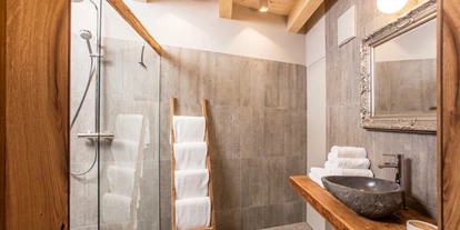 Hüttendorf - Weng (Goldegg) - Badezimmer mit Steinwaschbecken und Regendusche - ALPEGG CHALETS