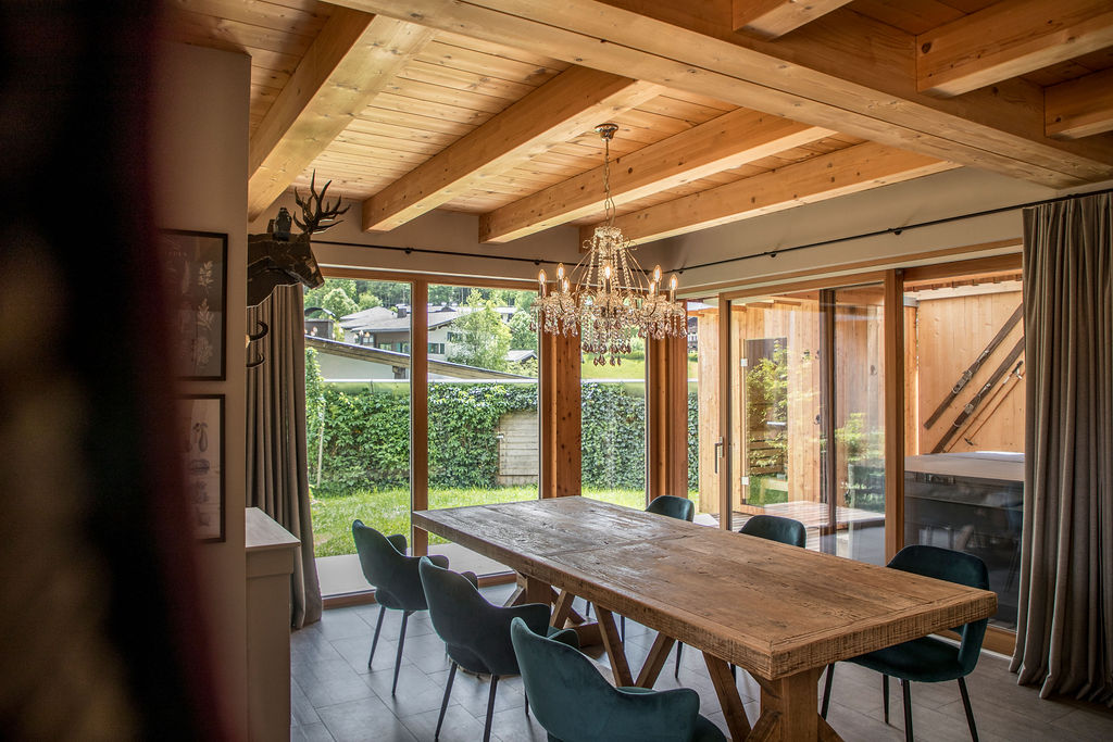 Chalet: Main Lodge: Großes Esszimmer mit Panoramafenstern und Blick auf den Garten, wo private Sauna und Whirlpool für entspannte Stunden warten. - BIO CHALETS ALPEGG
